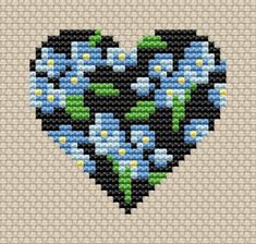 a cross stitch heart with blue flowers on it