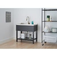 a bathroom sink sitting on top of a wooden floor next to a shelf filled with toiletries