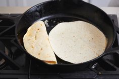 two tortillas are being cooked in a skillet on the gas stove top