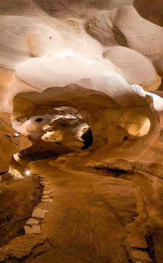 the inside of a cave with large rocks and rock formations on it's sides