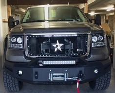 the front end of a silver truck with a star on it's grille and lights