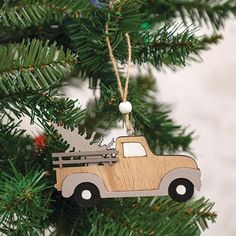 a wooden ornament hanging from a christmas tree with a truck on the front