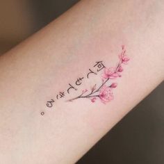 a woman's arm with a small tattoo on it that reads, love is in the air