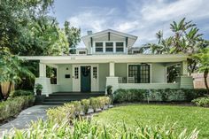 a white house with trees and bushes around it