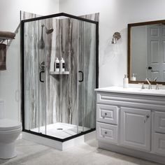 a bathroom with a toilet, sink and shower stall in the middle of the room