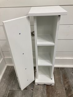 an open white cabinet on the floor