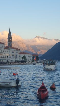 several small boats floating in the water near buildings