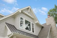 a white house with gray shingles and windows