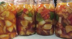 jars filled with pickled vegetables sitting on top of a counter next to each other