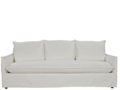 a white couch with four pillows on it's back and one arm facing the camera