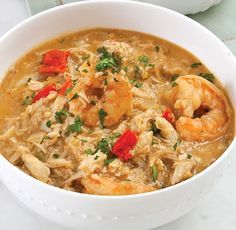 a white bowl filled with shrimp and rice soup on top of a marble countertop