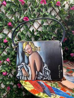 Hello Lamy friend, Right now you are looking at the custom handpainted bag with a painting by Tamara de Lempicka. The painting is made on a new Tommy Hilfiger bag. This is a one of a kind piece. It will be a perfect present for an anniversary, birthday, mothers day, wedding or any other occasion! I use wash and dust resistant leather paints Angelus that will guarantee you an incredible and lasting result. Want to see more of my work? Check out my creations on my Instagram @ksemo_custom, you will Artistic Hand-painted Satchel Shoulder Bag, Artistic Hand Painted Satchel Shoulder Bag, Artsy Hand Painted Rectangular Shoulder Bag, Elegant Hand Painted Rectangular Bag, Elegant Hand Painted Rectangular Bags, Artistic Hand Painted Satchel Bag, Artistic Hand Painted Shoulder Bag, Artistic Hand Painted Tote Shoulder Bag, Artistic Rectangular Evening Bag