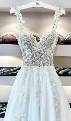 a white wedding dress hanging on a rack