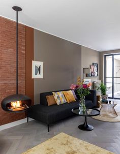 a living room filled with furniture and a fire place next to a wall mounted fireplace