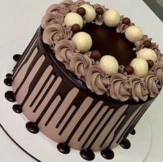 there is a chocolate cake with icing and decorations on the top, ready to be eaten