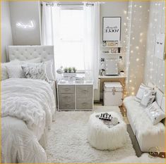 a bedroom decorated in white and silver with lights on the walls, bedding, rugs and pillows