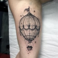 a hot air balloon tattoo on the right thigh, with an arrow in the middle