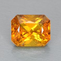 an orange diamond is shown on a gray surface and it looks like it has been cut in half