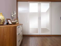 an empty room with wooden floors and white doors