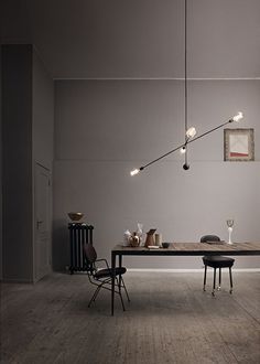 an image of a table and chairs in a room with light bulbs hanging from the ceiling