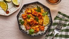 a bowl filled with rice, chicken and cilantro on top of a table