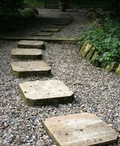 stone steps leading up to a bench in a garden