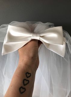 a person's hand holding up a white bow with the word dad written on it