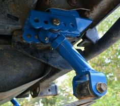 there is a blue piece of metal attached to the back of a vehicle's suspension