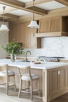 a large kitchen with wooden cabinets and white marble counter tops, along with two stools in front of the island