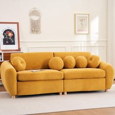 a yellow couch sitting on top of a hard wood floor next to a white rug