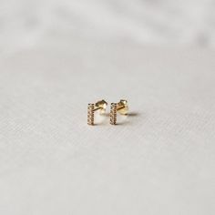 Pretty & simple stud earrings adorned with little cubic zirconia stones — perfect for your everyday.•  14k gold plating over sterling silver (hypoallergenic & nickel-free)•  Matching post backing•  Measures about 7mm long•  Ships as a pair (2 earrings total)Every order comes nicely packaged, ready for gift-giving! Please note that multiple items in the same order will be combined into one gift box. If the items are meant for separate individuals, please let me know.Shorter version availa Minimalist Gold Diamond Earrings For Gift, Gold Hypoallergenic Minimalist Diamond Earrings, Gold Minimalist Hypoallergenic Diamond Earrings, Everyday Minimalist Gold Diamond Earrings, Everyday Tiny Gold Diamond Earrings, Jewelry Necklace Simple, Simple Stud Earrings, 2 Earrings, Geometric Studs