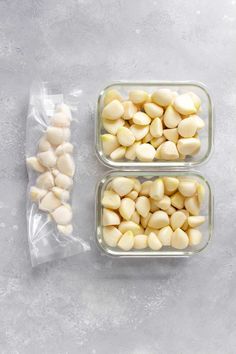 two glass containers filled with white beans on top of a gray surface next to each other