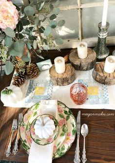 a place setting with candles, plates and napkins