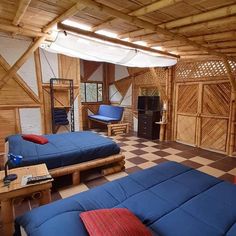 two beds in a room with wooden walls and flooring that is made out of wood planks