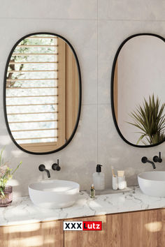 two round mirrors are above the sinks in this bathroom