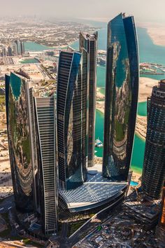 an aerial view of some very tall buildings in the middle of a large body of water