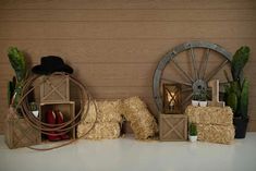 hay bales stacked on top of each other in front of a wooden wall with an old wheel