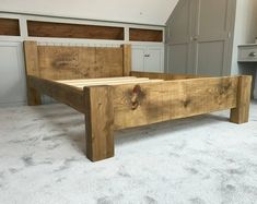 a wooden bed frame sitting on top of a carpeted floor