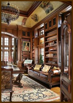 a living room filled with lots of wooden furniture and bookshelves covered in paintings