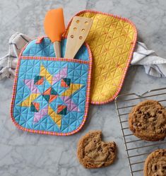 chocolate chip cookies and an oven mitt on a marble counter with baking utensils