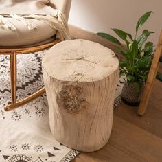 a wooden stump sitting on top of a rug next to a chair