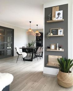 a dining room and kitchen area with wood flooring, gray walls and white furniture