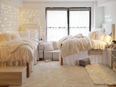 a bedroom with white bedding and lights on the windowsills, carpeted floor