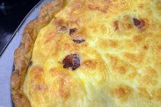 a cheesy quiche sitting on top of a metal pan