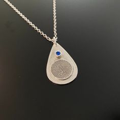 "ABOUT THIS LISTING: Fingerprint Jewelry is uniquely personal and a constant reminder of your loved ones .... past or present. This teardrop shape pendant is approximately 1\" and includes a 3mm birthstone CZ set in a sterling silver bezel and a raised 1/2 inch fingerprint disk. We can add custom text or actual handwriting on the back side. Also available is a Rolo Style, 18\" Sterling Silver Chain with lobster clasp. ORDER OPTIONS: Teardrop Shaped Pendant with CZ Birthstone: $215.00 Pendant wit Sterling Silver Teardrop Birthstone Necklace Gift, Silver Teardrop Birthstone Necklace For Gift, Silver Teardrop Sterling Silver Birthstone Necklace, Silver Teardrop Gemstone Birthstone Necklace, Silver Teardrop Pendant Birthstone Necklace, Sterling Silver Teardrop Necklace With Bezel Setting, Teardrop Sterling Silver Keepsake Jewelry, Sterling Silver Teardrop Keepsake Jewelry, Silver Teardrop Birthstone Necklace