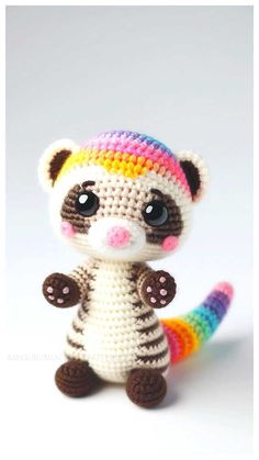 a small crocheted animal with a rainbow colored tail