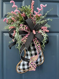 a door hanger decorated with pink and black flowers, leopard print boot and ribbon