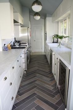 a long narrow kitchen with herring tile flooring