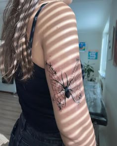 a woman with a spider tattoo on her arm