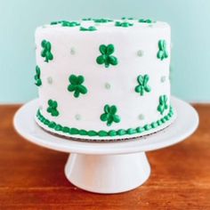 a white cake with green shamrocks on it